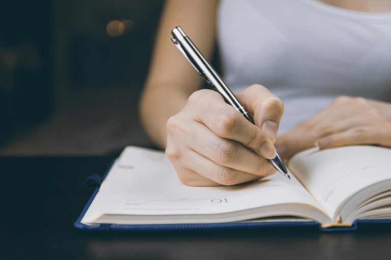 image d'une femme entrain d'écrire sur un livre